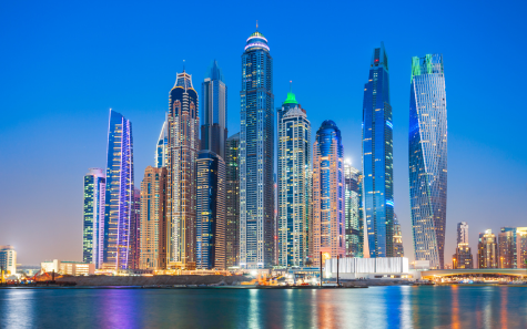 Modern Dubai city skyline at night with colorful lights and tall buildings