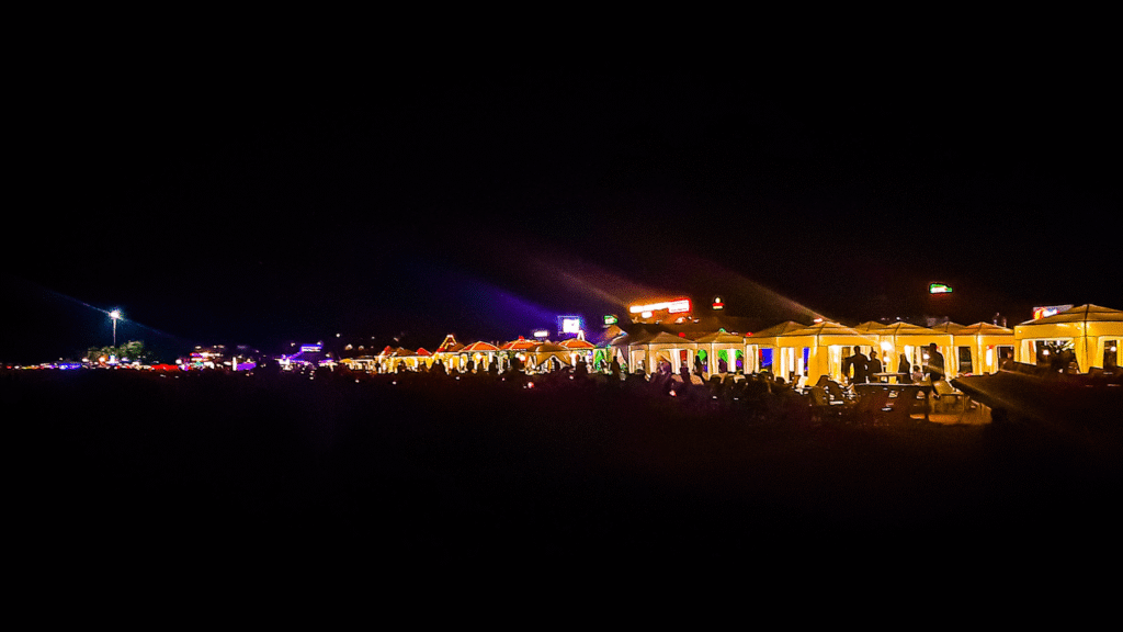 Baga Beach at night with colorful lights and lively beachside shacks